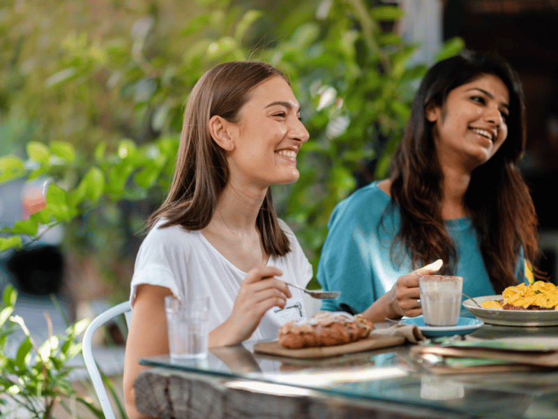 two girls having lunch smiling